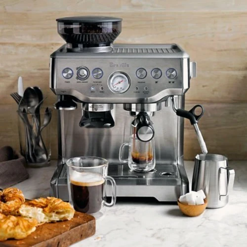 Breville BES870XL Barista Express set up on a kitchen counter with espresso cups